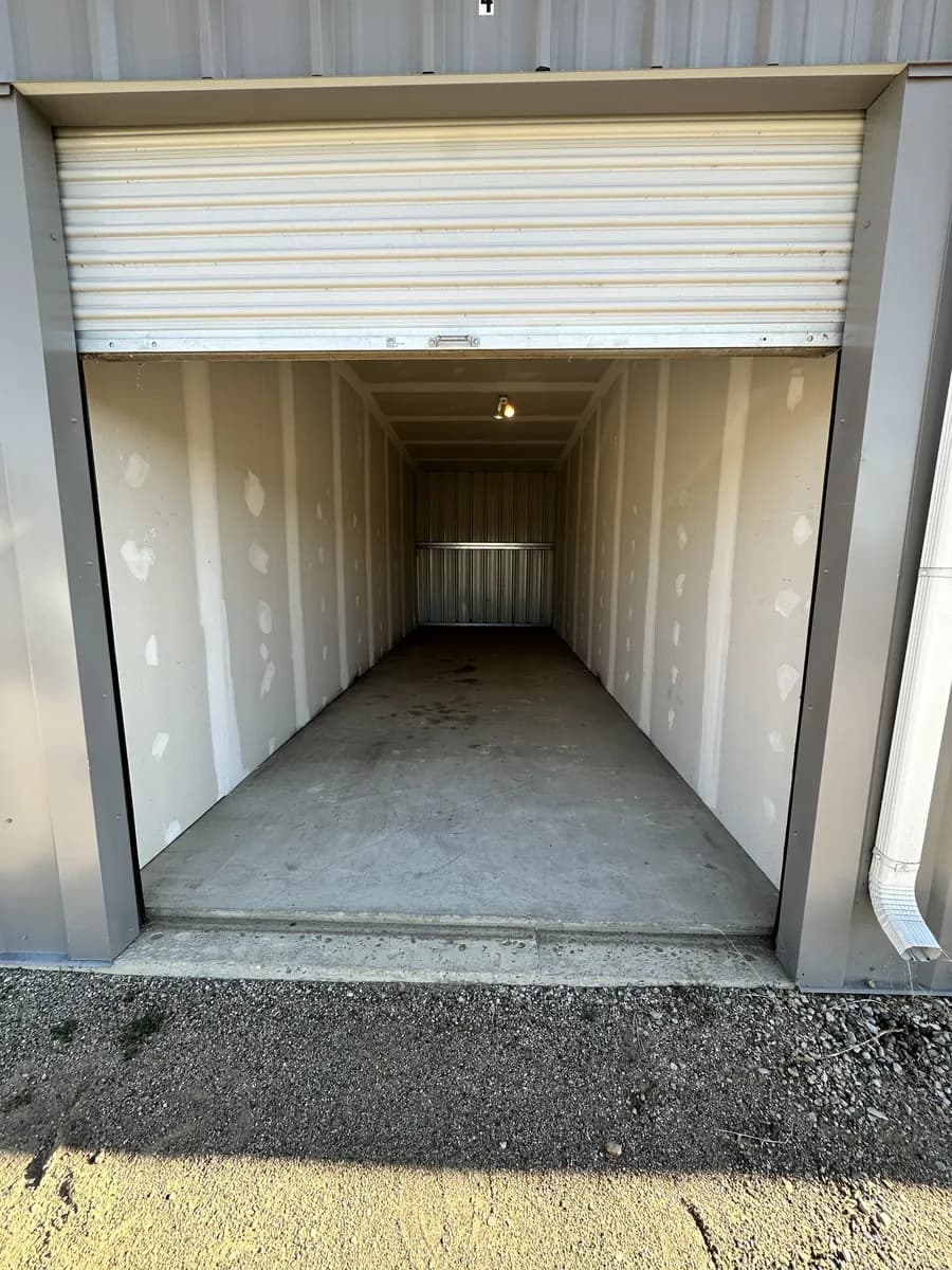 A storage bay with its roll-up door open, showing the long empty interior